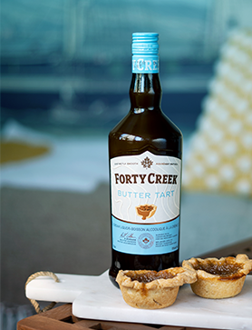 A bottle of new Butter Tart Cream Liquor with butter tarts