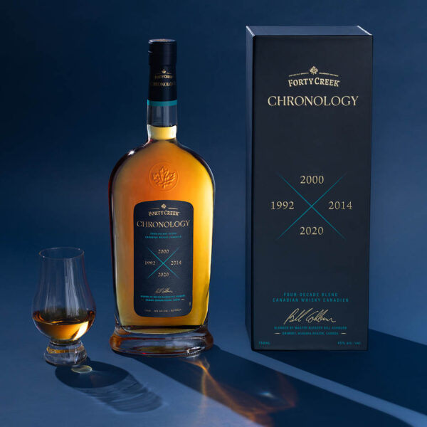 A bottle and signed box of Chronology blended whisky with whisky in a tasting glass