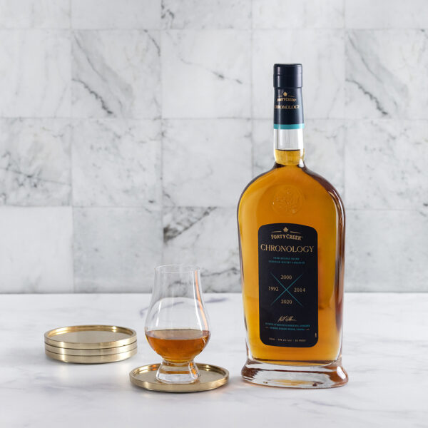 A bottle and glass of Forty Creek Chronology whisky